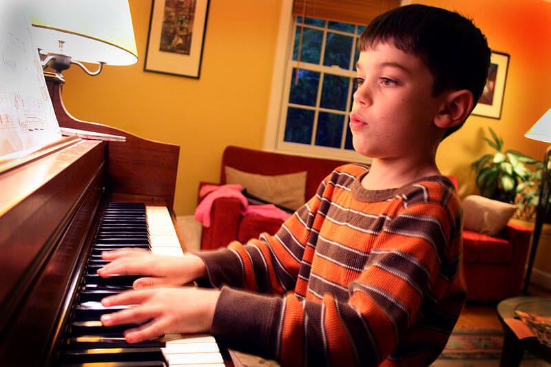 Photo of a young boy practicing piano